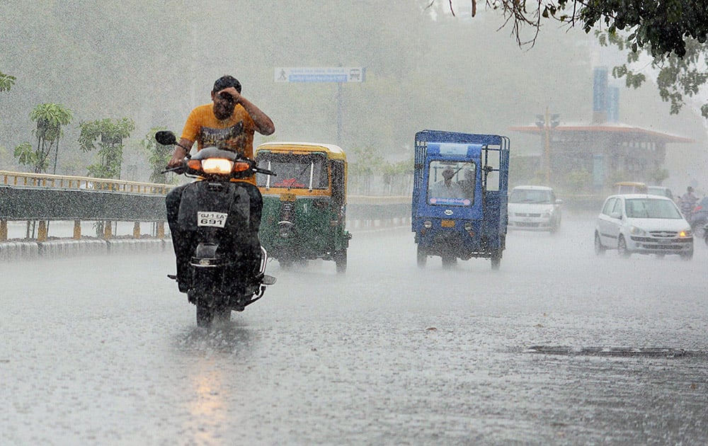 People commute in heavy rains in Ahmedabad.