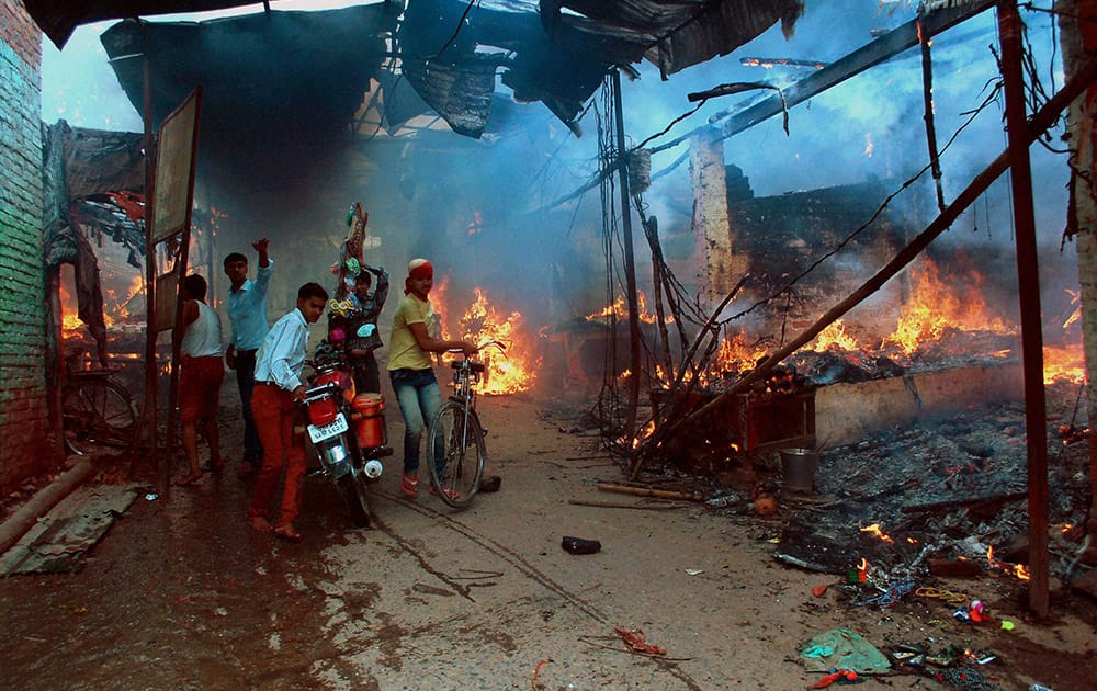 Residents salvage their belongings during a massive fire at New VIP Market in Vindhyachal, Mirzapur.