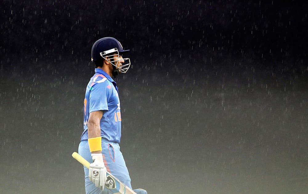 Robin Uthappa walks back to the pavilion after their second one-day International cricket match against Bangladesh is interrupted due to rain in Dhaka, Bangladesh.