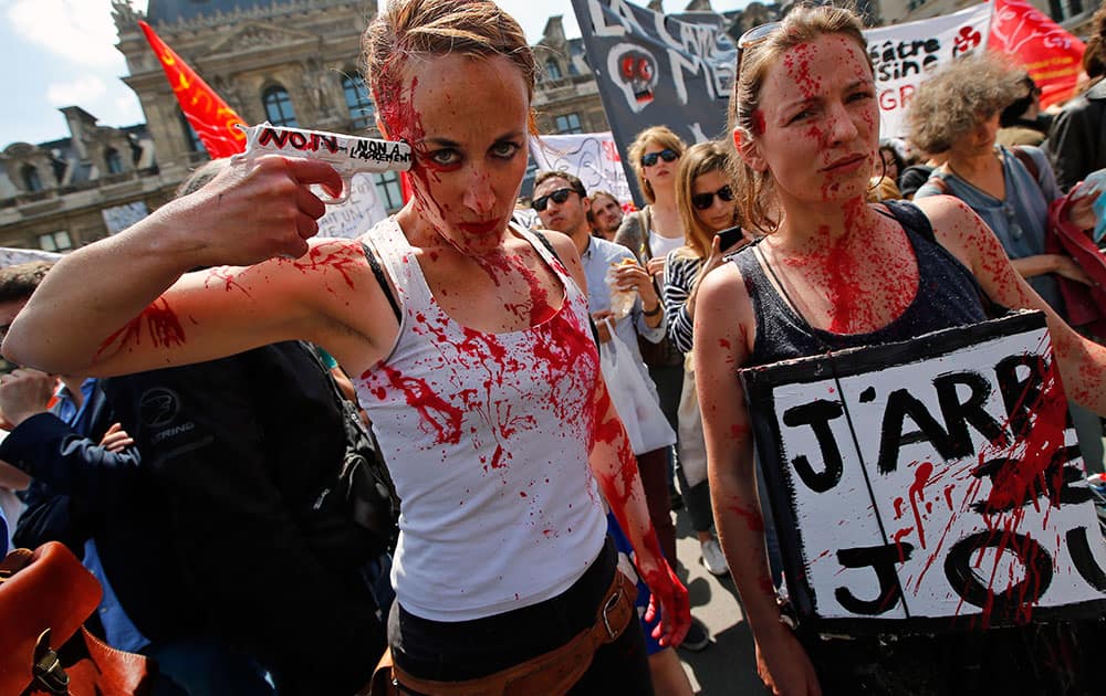 A woman points a plastic gun in a mock suicide as she attends a gathering of part-time and temporary arts workers, striking artists and theater personnel, known as `intermittents`, to protest against government plans to reform the unemployment benefits insurance agreement in Paris.