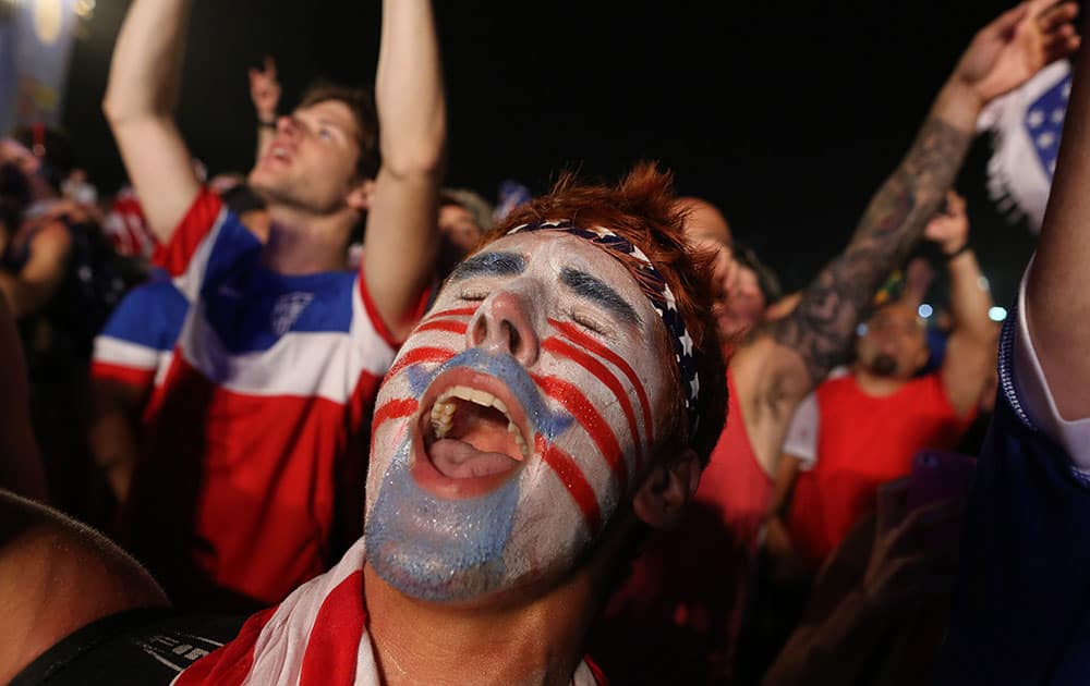 A fan of the U.S. national soccer team celebrates his team`s victory during a live broadcast of the soccer World Cup match between the Unites States and Ghana, inside the FIFA Fan Fest area on Copacabana beach, Rio de Janeiro, Brazil.