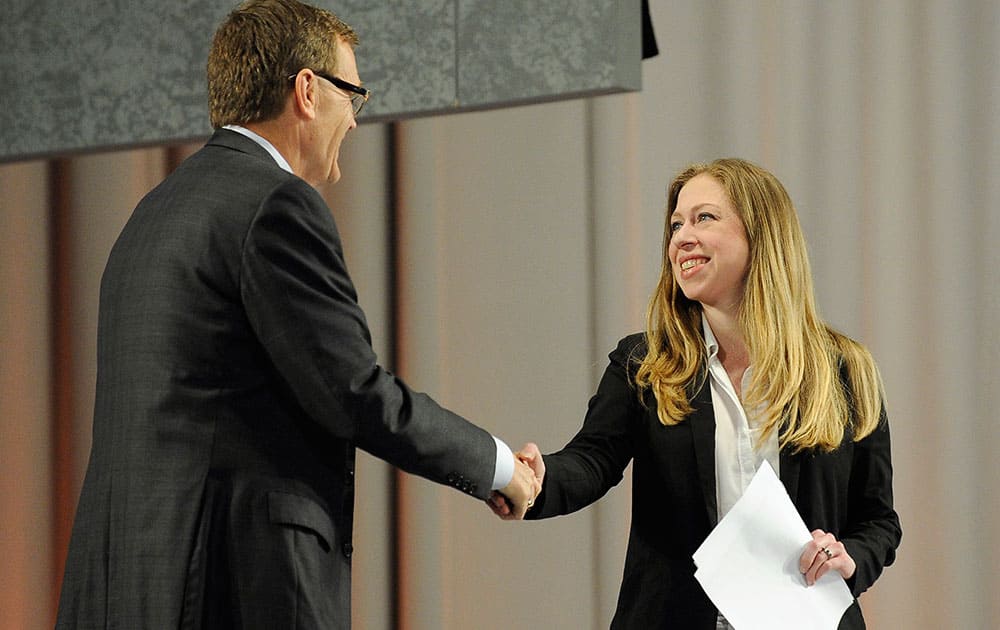 Chelsea Clinton, right, is introduced by UPS CEO-elect David Abney, left, at the opening plenary session for the `Service Unites` conference sponsored by the Points of Light Foundation, in Atlanta. Clinton called for more opportunities to engage millennials in community service during her speech.