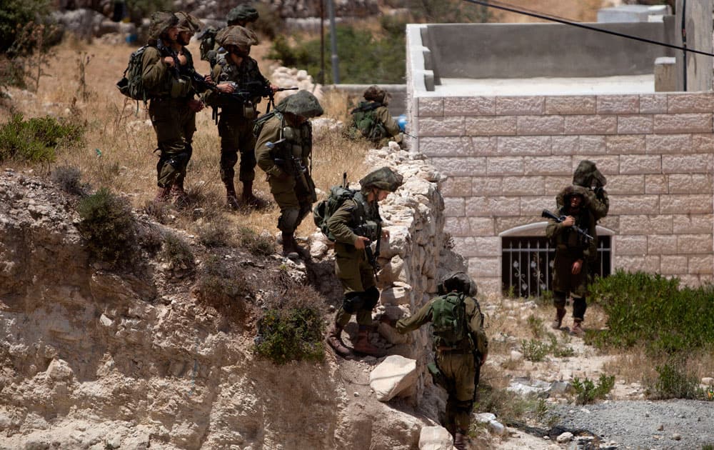 Israeli soldiers conduct a military operation to search for three missing teenagers outside the West Bank city of Hebron.