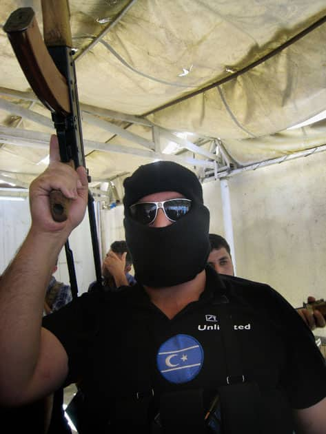 An Iraqi Turkoman fighter raises his rifle during an announcement proclaiming the formation of a defense system to protect their own areas at the Iraqi Turkmen Front Headquarters in the oil-rich city of Kirkuk, 180 miles (290 kilometers) north of Baghdad, Iraq.