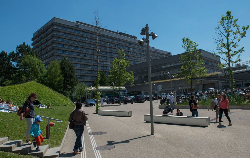 People walk in front of the Lausanne University Hospital (the ``CHUV``) in Lausanne, Switzerland. Former German Formula One driver Michael Schumacher is no longer in a coma and has left a French hospital where he had been receiving treatment since a skiing accident in December, but has been transferred to the Lausanne University Hospital his manager said.