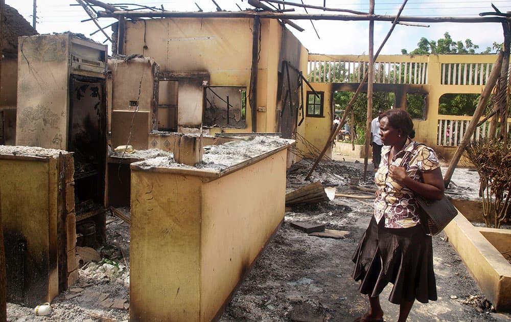 A woman observes the remains of the Breeze View Hotel, where residents watching the World Cup soccer tournament, were attacked and killed by militants, in the town of Mpeketoni, about 100 kilometers (60 miles) from the Somali border on the coast of Kenya.