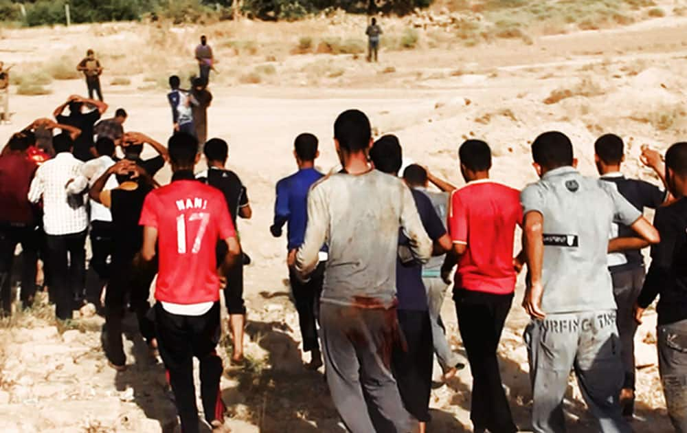 This image posted on a militant website on Saturday, June 14, 2014, which has been verified and is consistent with other AP reporting, appears to show militants from the al-Qaida-inspired Islamic State of Iraq and the Levant (ISIL) leading captured Iraqi soldiers wearing plain clothes to an open field moments before shooting them in Tikrit, Iraq.