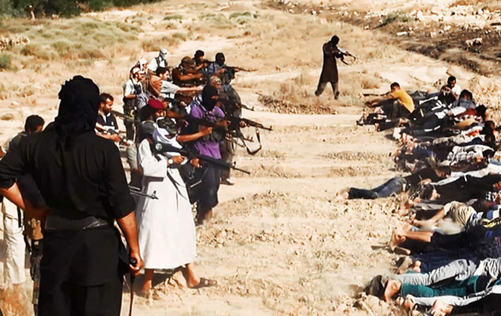 This image posted on a militant website on Saturday, June 14, 2014, which has been verified and is consistent with other AP reporting, appears to show militants from the al-Qaida-inspired Islamic State of Iraq and the Levant (ISIL) taking aim at captured Iraqi soldiers wearing plain clothes after taking over a base in Tikrit, Iraq.