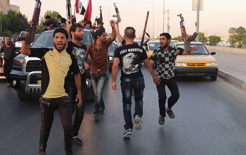 Shiite tribal fighters raise their weapons and chant slogans against the al-Qaida-inspired Islamic State of Iraq and the Levant (ISIL) in Basra, Iraq`s second-largest city, 340 miles (550 kilometers) southeast of Baghdad, Iraq.