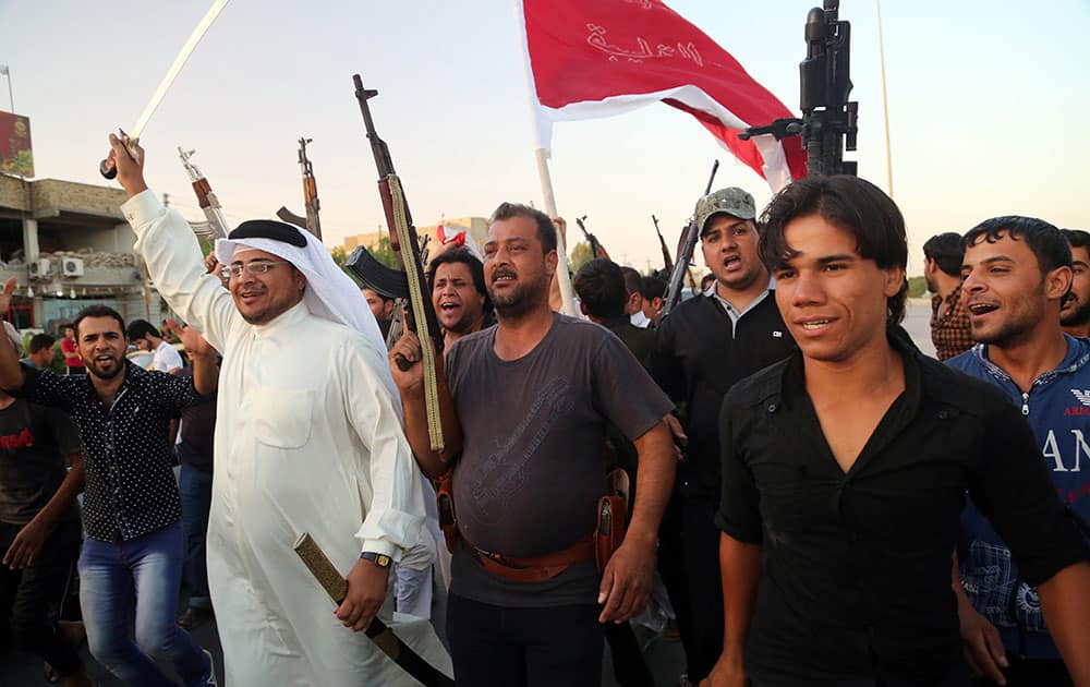 Shiite tribal fighters raise their weapons and chant slogans against the al-Qaida-inspired Islamic State of Iraq and the Levant (ISIL) in Basra, Iraq`s second-largest city, 340 miles (550 kilometers) southeast of Baghdad, Iraq.