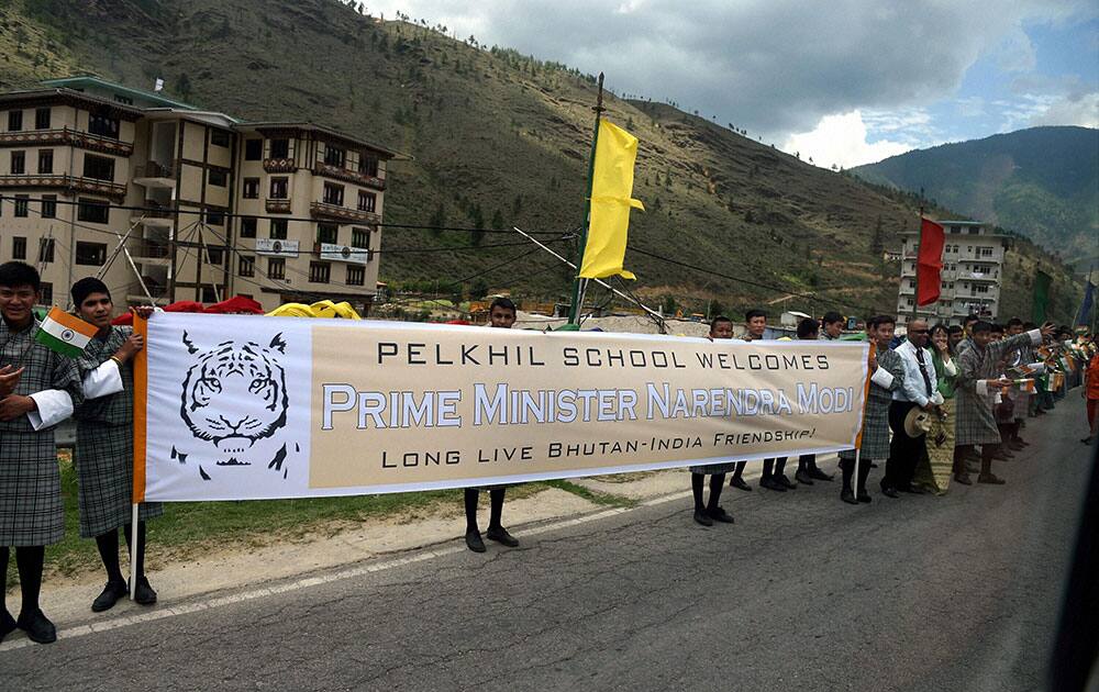 School students hold a banner welcoming Prime Minister Narendra Modi as his motorcade passes in Thimphu in Bhutan.