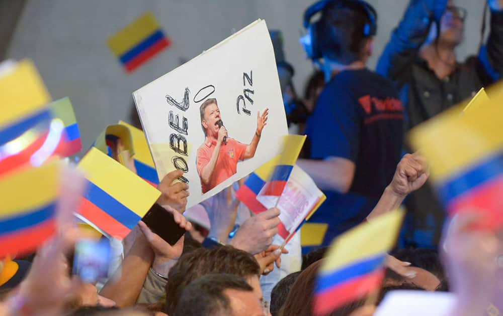 A supporter of President Juan Manuel Santos holds a sign with his photo that reads in Spanish `Nobel Peace Prize` during his victory rally in Bogota, Colombia.