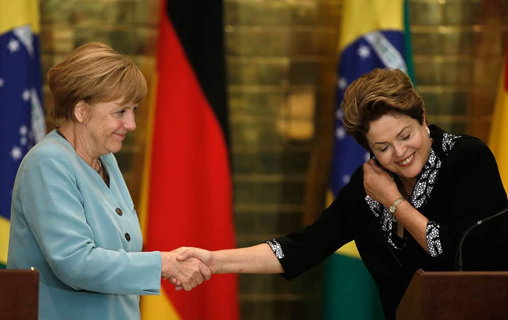 Germany`s Chancellor Angela Merkel, left, shakes hands with Brazil`s President Dilma Rousseff after a news conference at Alvorada Palace in Brasilia, Brazil.