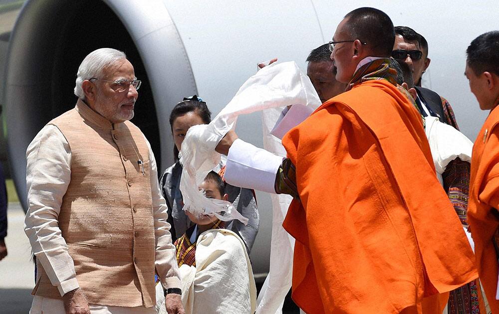 Prime Minister Narendra Modi being received by his Bhutanese counterpart Tshering Tobgay on his arrival at the Paro International Airport in Bhutan.