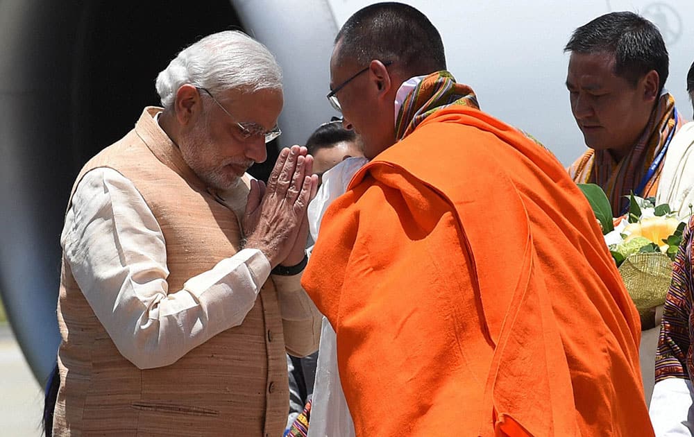  Prime Minister Narendra Modi being received by his Bhutanese counterpart Tshering Tobgay on his arrival at the Paro International Airport in Bhutan.