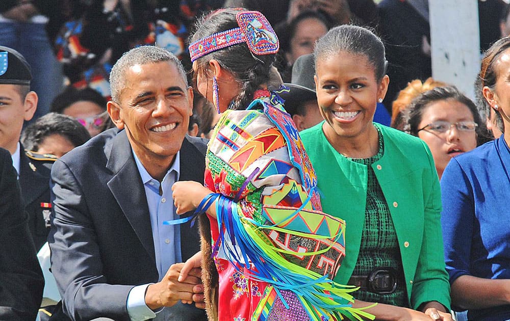 President Barack Obama and first lady Michelle Obama greet a young dancer after an honoring song inside the Cannon Ball, ND, community pow wow arbor. Obama on Friday became only the third US sitting president in eight decades to set foot in Indian Country, encountering both the wonder of Native American culture and the struggle of tribal life on a breeze-whipped afternoon in the prairie. 