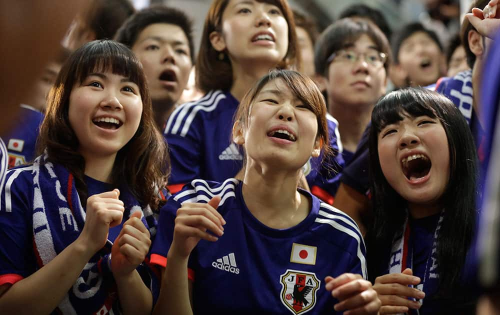 Japanese soccer fans watch a live broadcast of the group C World Cup soccer match between Japan and Ivory Coast at a public viewing venue in Tokyo.