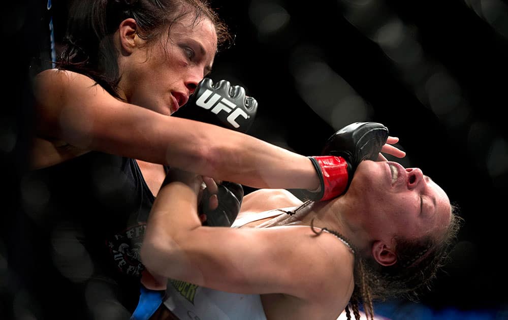 Valerie Letourneau, left, of Canada, punches Elizabeth Phillips, of the United States, during a women`s bantamweight bout at UFC 174 in Vancouver, British Columbia.