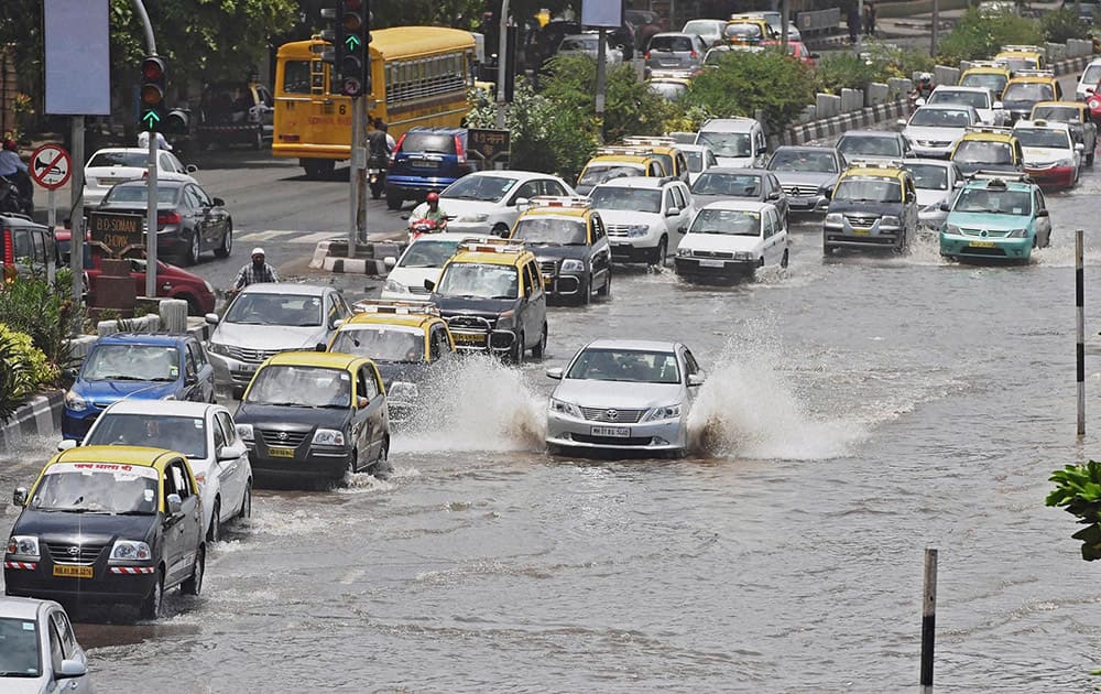 Vehicles plying on the Marine drive inundated by a high tide in Mumbai.