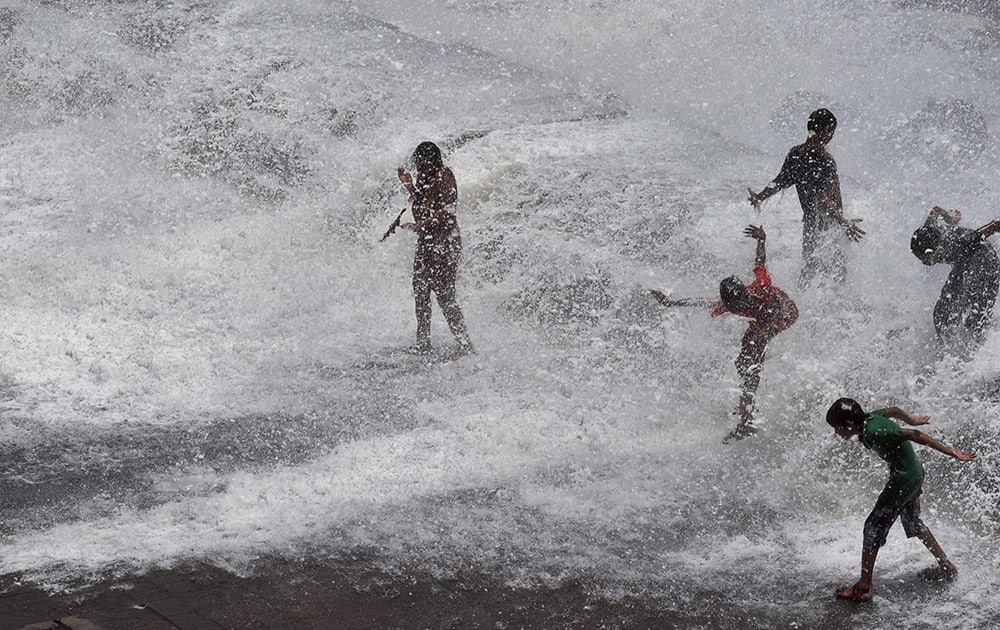 People enjoy high tide at Marine drive in Mumbai.