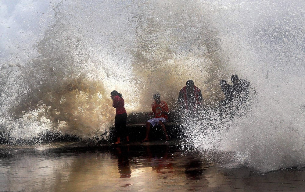 Visitors enjoy high tide at Marine Drive in Mumbai.