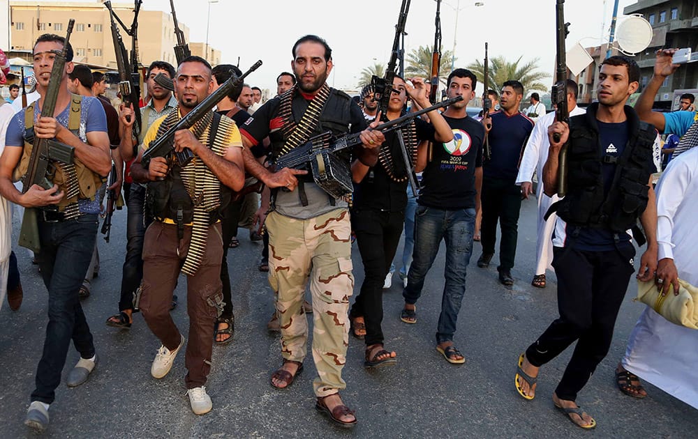 Iraqi Shiite tribal fighters deploy with their weapons while chanting slogans against the al-Qaida inspired Islamic State of Iraq and the Levant (ISIL), to help the military, which defends the capital in Baghdad`s Sadr City, Iraq.