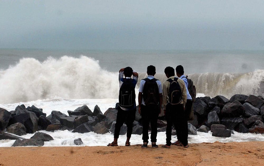 Visitors watch sea waves striking against the shore at Ullal near Mangalore.