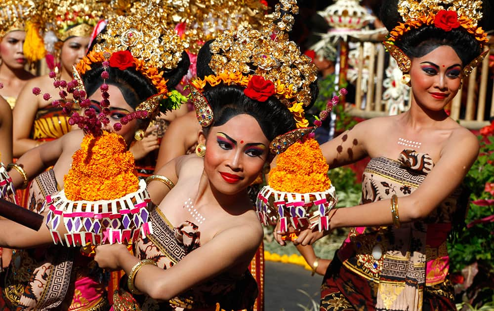 Indonesian dancers in traditional outfit perform during a parade to mark the Bali Arts Festival in Bali, Indonesia.