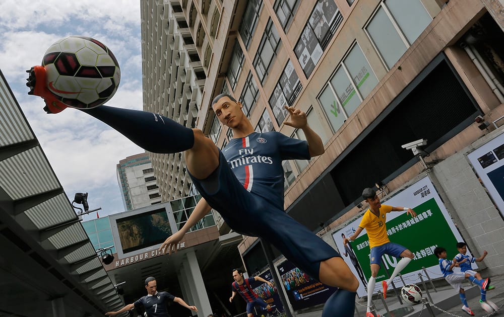 Giant size figures of Swedish striker Zlatan Ibrahimovic, left, and Brazilian striker Neymar, right, are displayed outside a shopping mall in Hong Kong.