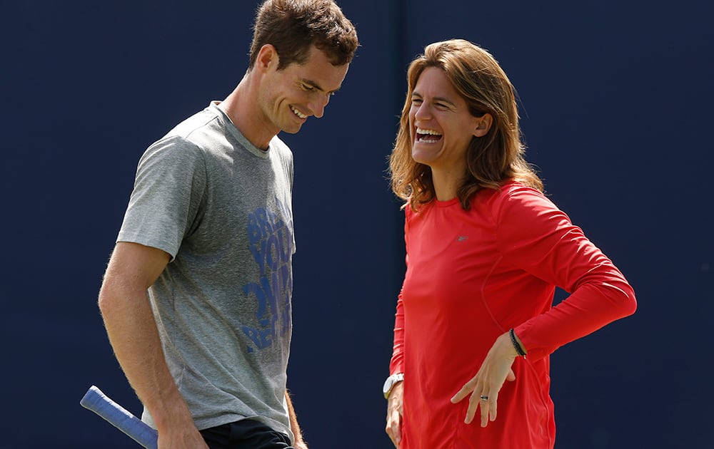 Andy Murray of Britain shares a laugh with his new coach Amelie Mauresmo during a training session before his Queen`s Club grass court championships tennis match in London.