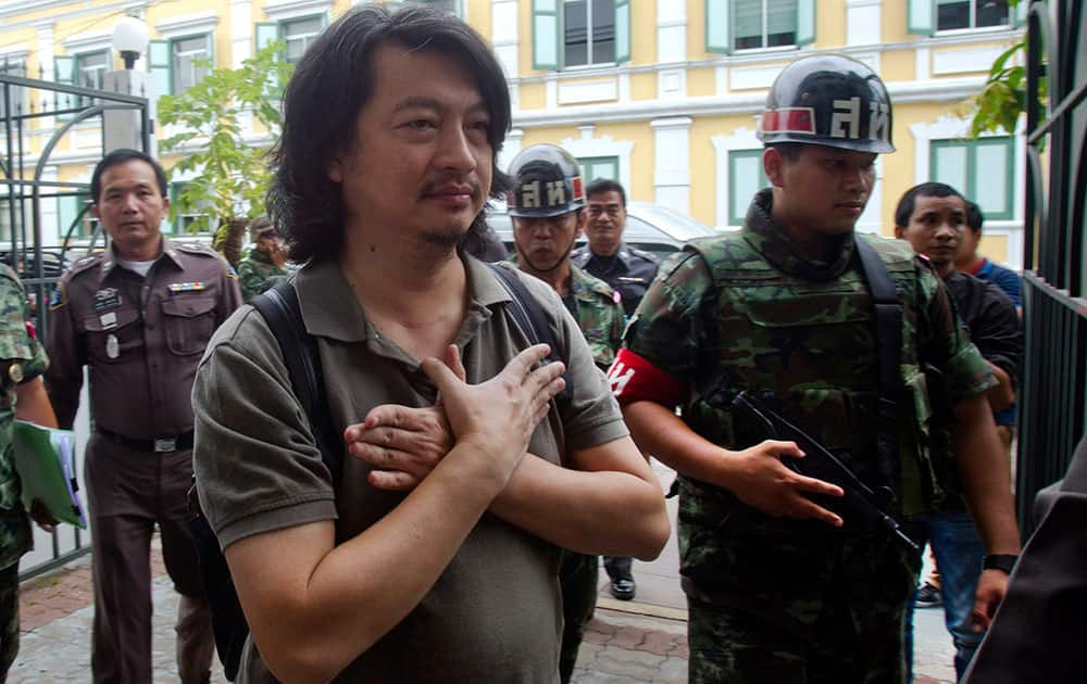 Sombat Boonngam-anong gestures a sign of freedom while arriving at the military court in Bangkok, Thailand.