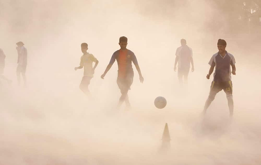 10ThingstoSeeSports - Aspiring young Indian soccer players continue with their practice during a dust storm in Jammu, India.