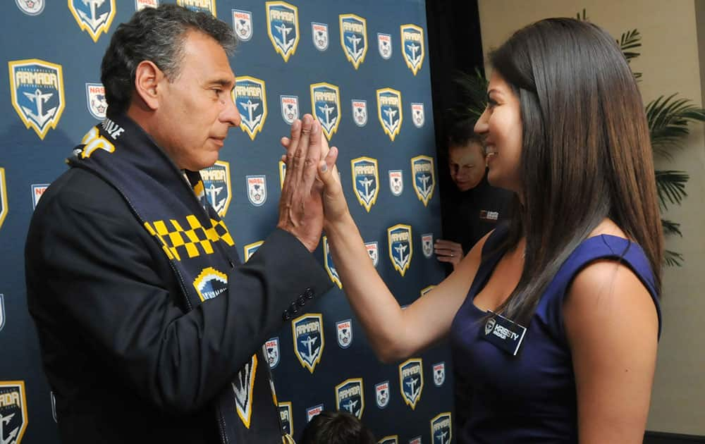 Jacksonville Armada FC multimedia coordinator and interpreter Krissty Andaur, right, high-fives newly announced head coach Jose Luis Villarreal during a soccer news conference in Jacksonville, Fla.