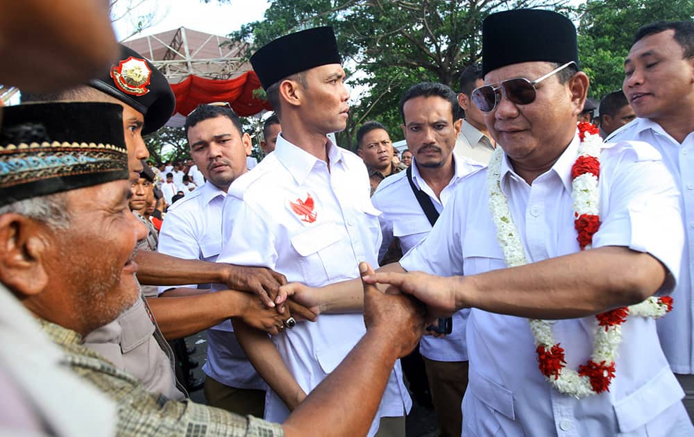 Indonesian presidential candidate Prabowo Subianto, right, greets supporters during a campaign rally in Banda Aceh, Aceh province, Indonesia.