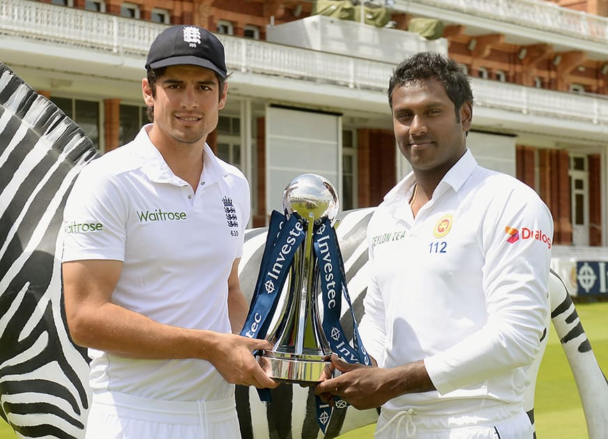 England`s Alastair Cook and Sri Lanka`s Angelo Matthews pose with the series trophy during a nets session at Lords Cricket Ground, London. The first test in the current series between the two sides begins at Lord`s on Thursday.