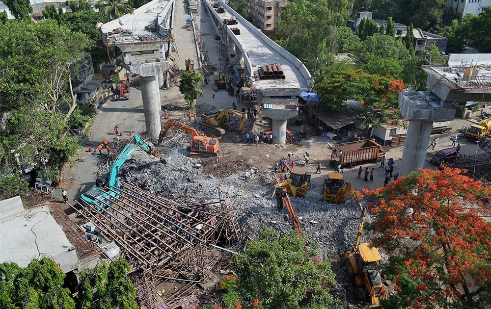 Cranes clear the debris of a collapsed flyover in Surat, a day after the mishap.