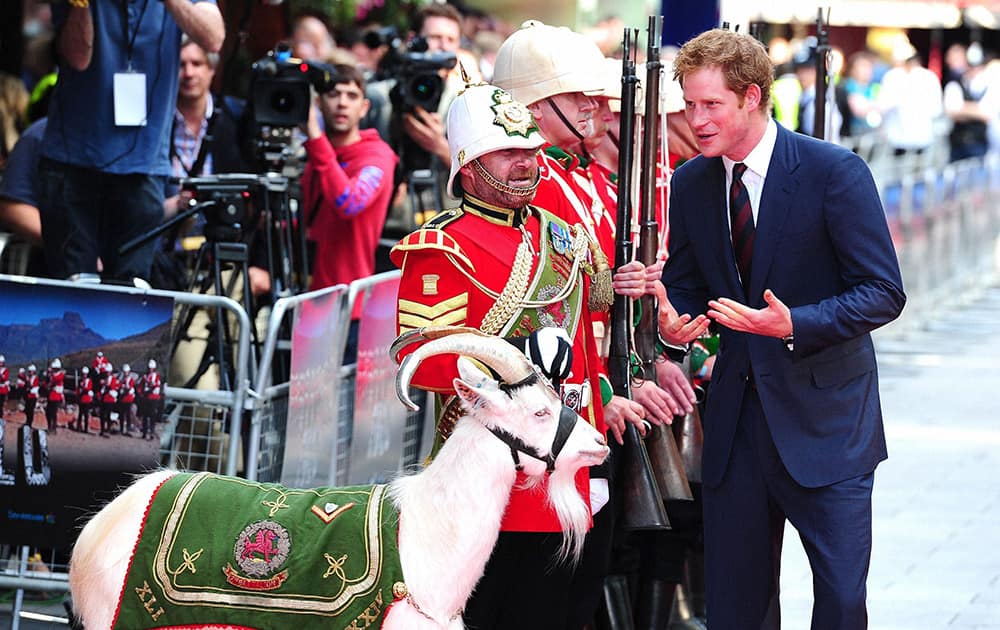 Britain`s Prince Harry, right, meets Sgt `Jacko` Jackson, Goat Major, with Shenkin, the regimental mascot of the 3rd Battalion, as he attends the 50th anniversary screening of the digitally re-mastered movie Zulu, in London.