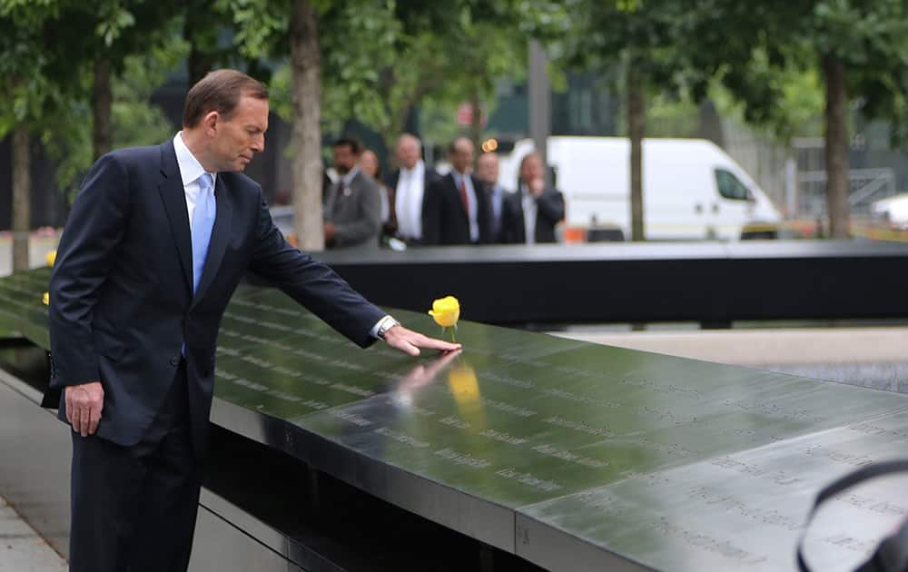 Australian Prime Minister Tony Abbott touches a panel of engraved names at the National September 11 Memorial in New York.