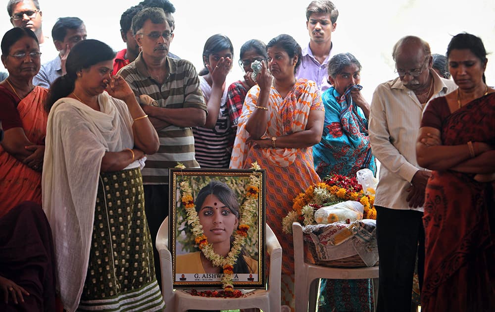 Relatives and friends mourn next to a portrait of Gampala Aishwarya, one of the students who was swept away in a sudden dam release, during her funeral at her residence in Hyderabad.