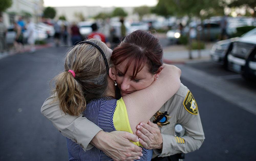 Cheri Rasmussen, left, embraces Las Vegas Metropolitan Police Lt. Roxanne McDaris after a vigil near CiCi`s Pizza in Las Vegas. 