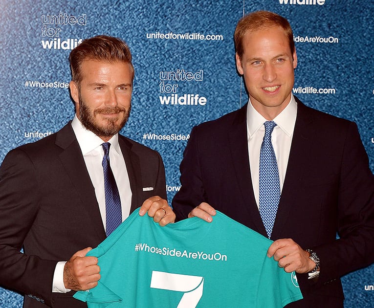 Britain`s Prince William and David Beckham display a a T-shirt signed by them both during the launch of the #WhoseSideAreYouOn campaign, aimed at using the power of sport to combat illegal trade in wildlife products, in central London.