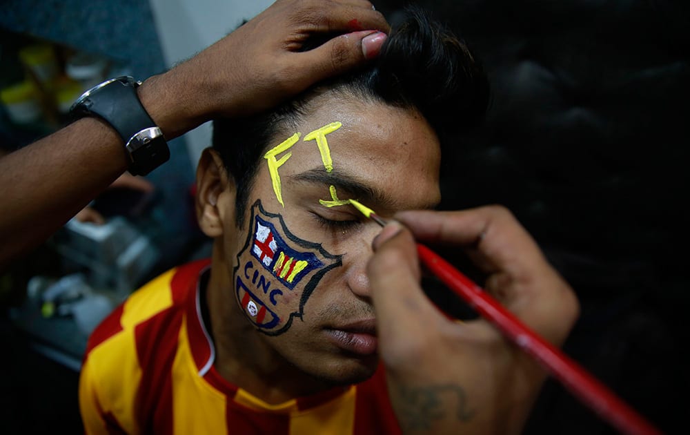 An Indian youth gets his face painted as part of a promotional event ahead of the soccer World Cup at a saloon in Mumbai. Soccer fans around the world are gearing up to watch the upcoming World Cup soccer tournament in Brazil.