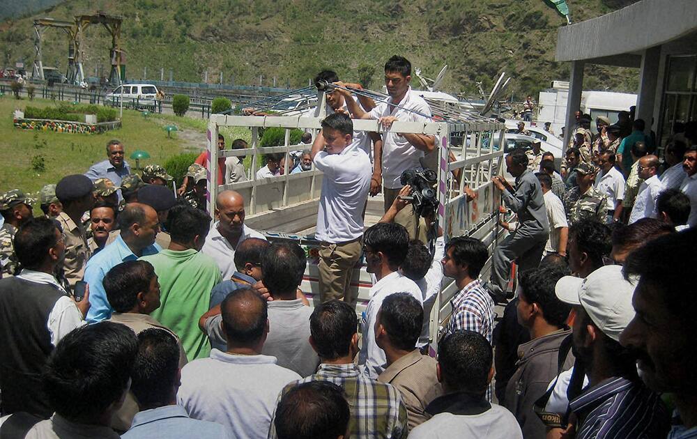 People crowd as a rescue jeep arrives at Pandoh Dam in Mandi on Monday. Rescue work is carried out near the dam to search for the bodies of engineering students from Hyderabad who were washed away on Sunday evening in the River near Thalot after release of water from Larji Dam. 