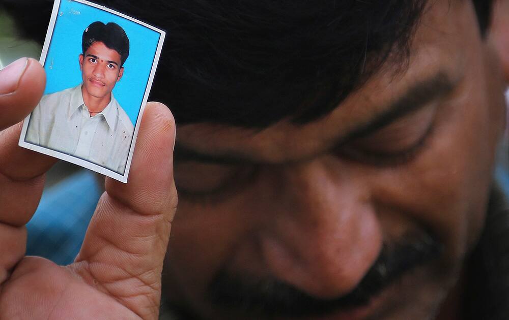 Bonath Shekar Naik shows a portrait of his son Rambabu, only one name available, one of the 24 students feared dead during a field trip near the mountain resort town of Manali, at the college premises of VNR Vignana Jyothi Institute of Engineering and Technology, on the outskirts of Hyderabad.