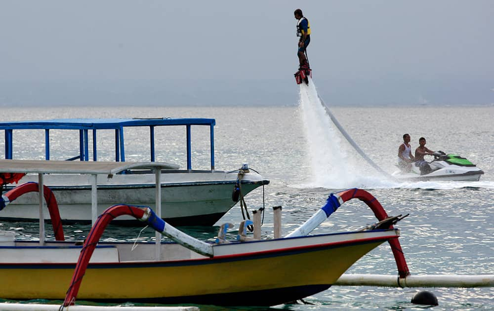 A tourist flies with his water-propellled jetpack in the ocean in Bali, Indonesia.