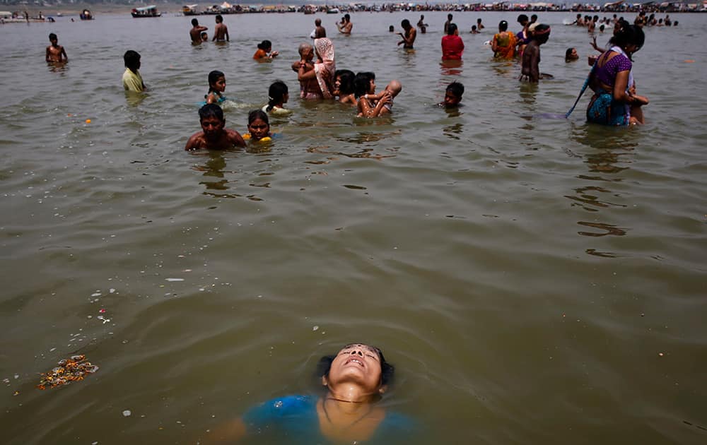 A woman bathes in the river Ganges on a hot summer afternoon in Allahabad.