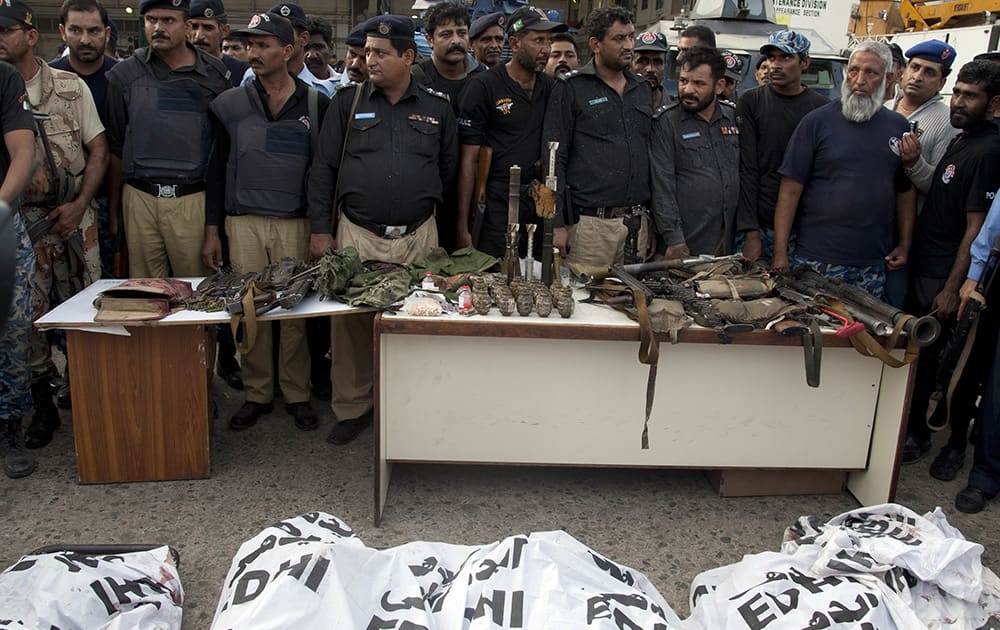 Pakistani police officers display confiscated ammunition and the dead bodies of terrorists who attacked the Jinnah International Airport in Karachi, Pakistan.