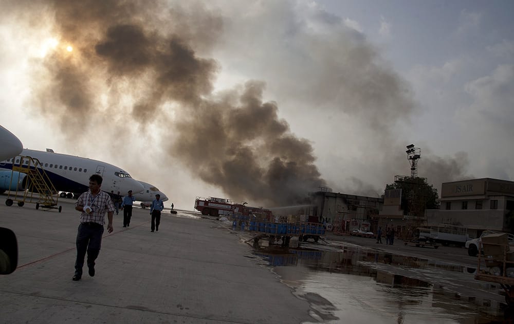 Smoke rises above the Jinnah International Airport where security forces continue to battle militants in Karachi, Pakistan. 