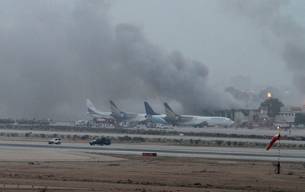 Smoke rises above the Jinnah International Airport where security forces continue to battle militants in Karachi, Pakistan.