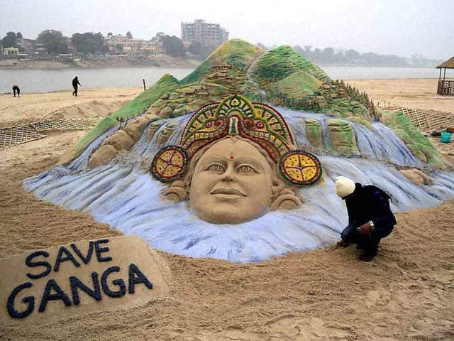 Renowned sand artist Sudarsan Pattnaik creates a sand sculpture of Ganga near the river bank with a message `Save Ganga` in Patna.